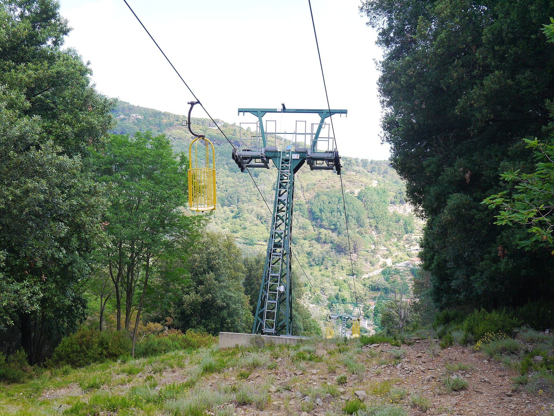 Les cages jaunes ouvertes du téléphérique du Monte Capanne au-dessus des bois de Marciana